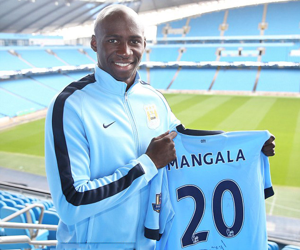 Eliaquim Mangala holding Manchester City jersey in 2014-2015